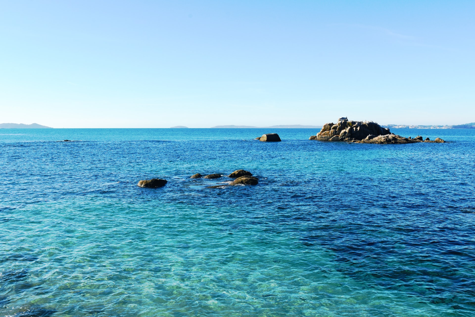 costa rocosa sota un cel blau durant el dia